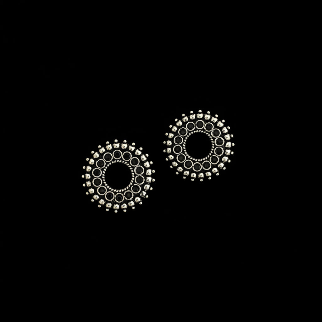 Pair of silver circular earrings on a dark background