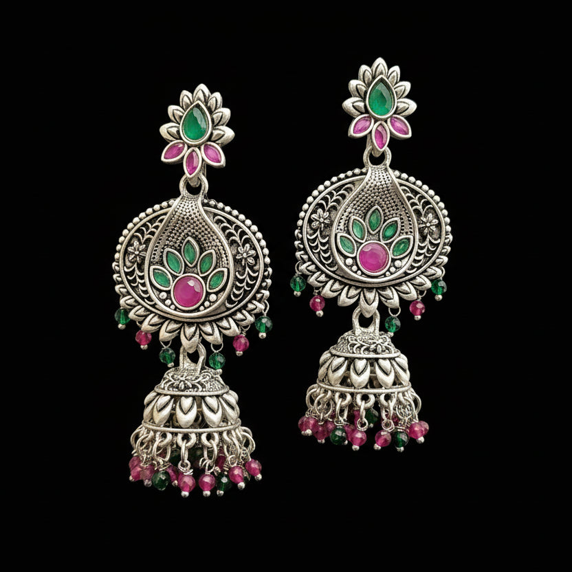 Ornate silver earrings with pink and green accents on a gray stand with HP logo.