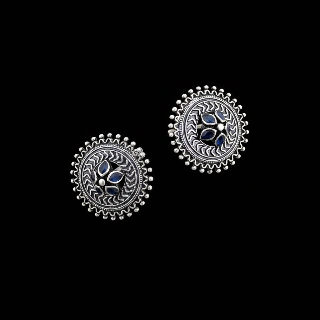 Pair of silver earrings with blue gemstones on a gray background