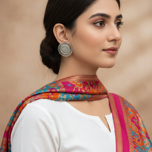 Pair of silver floral earrings on a gray background
