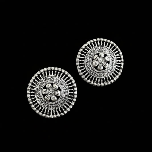 Pair of silver floral earrings on a black background