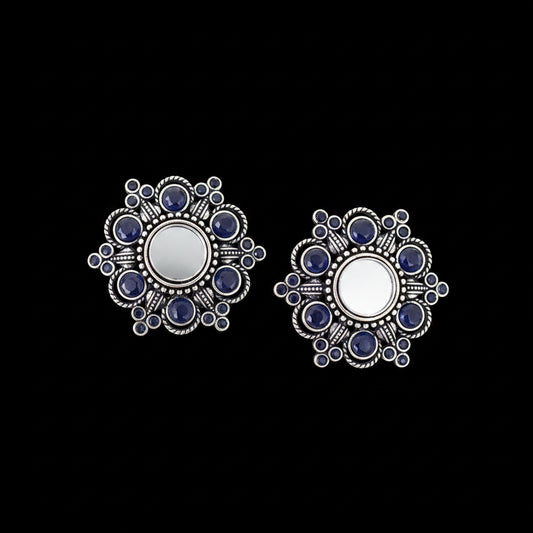 Silver earrings with blue stones on a gray background, branded 'Saheli'.