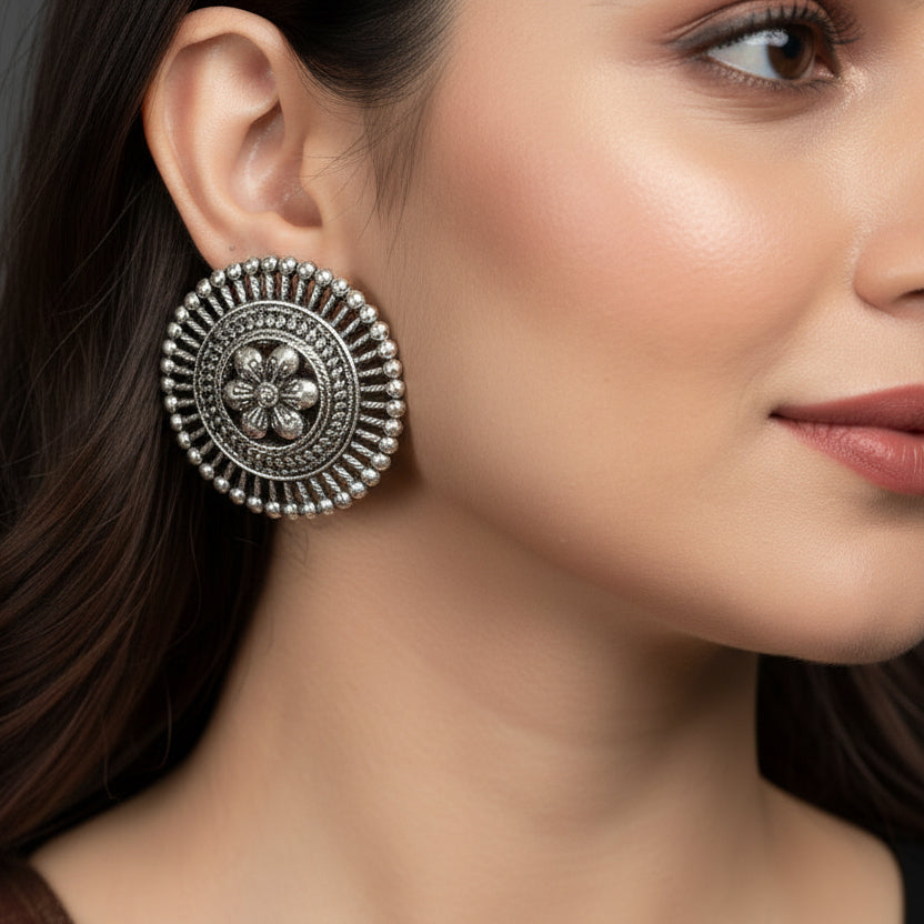 Pair of silver floral earrings on a black background