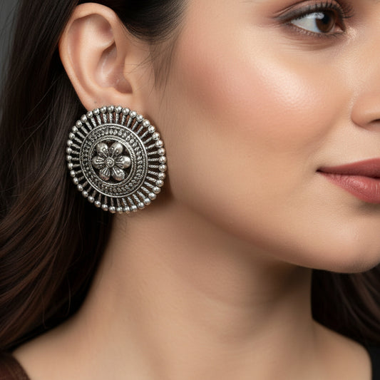Pair of silver floral earrings on a black background