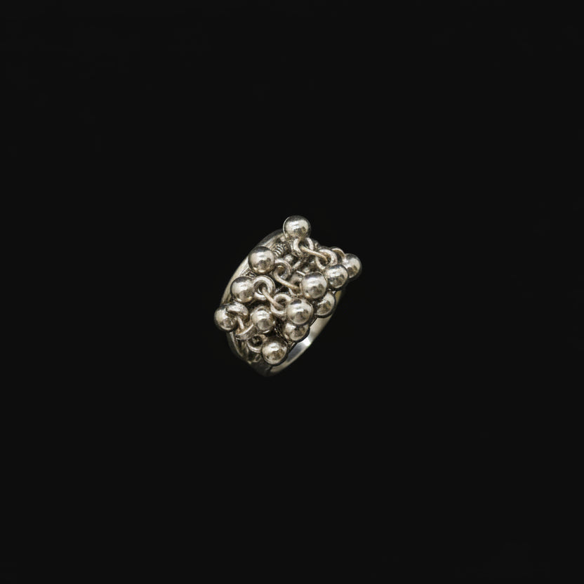 Silver ring on a black mannequin hand against a dark background
