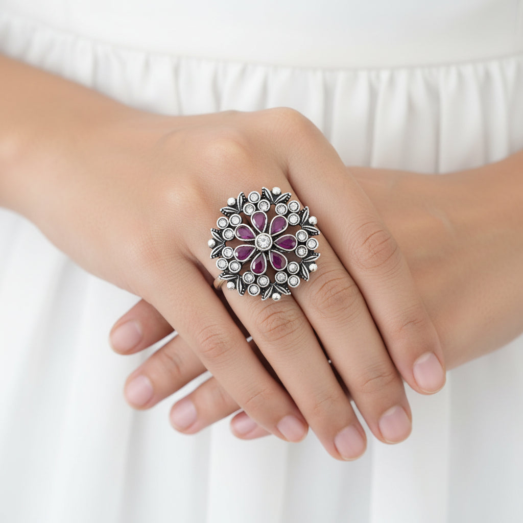 Decorative ring with purple gemstones on a mannequin hand, branded 'Saheli'.