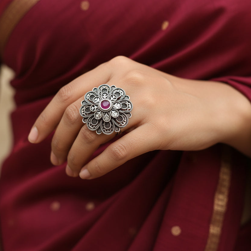 Decorative ring with a red gemstone on a dark gray background