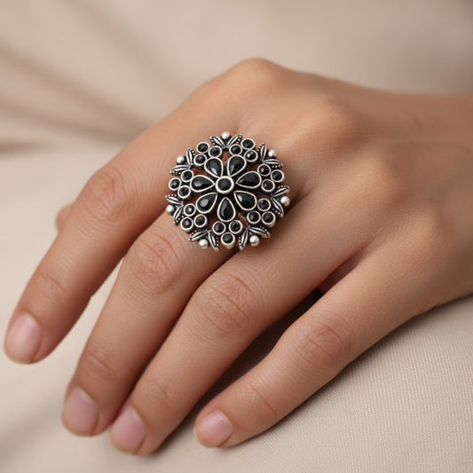 Silver floral ring on a gray background