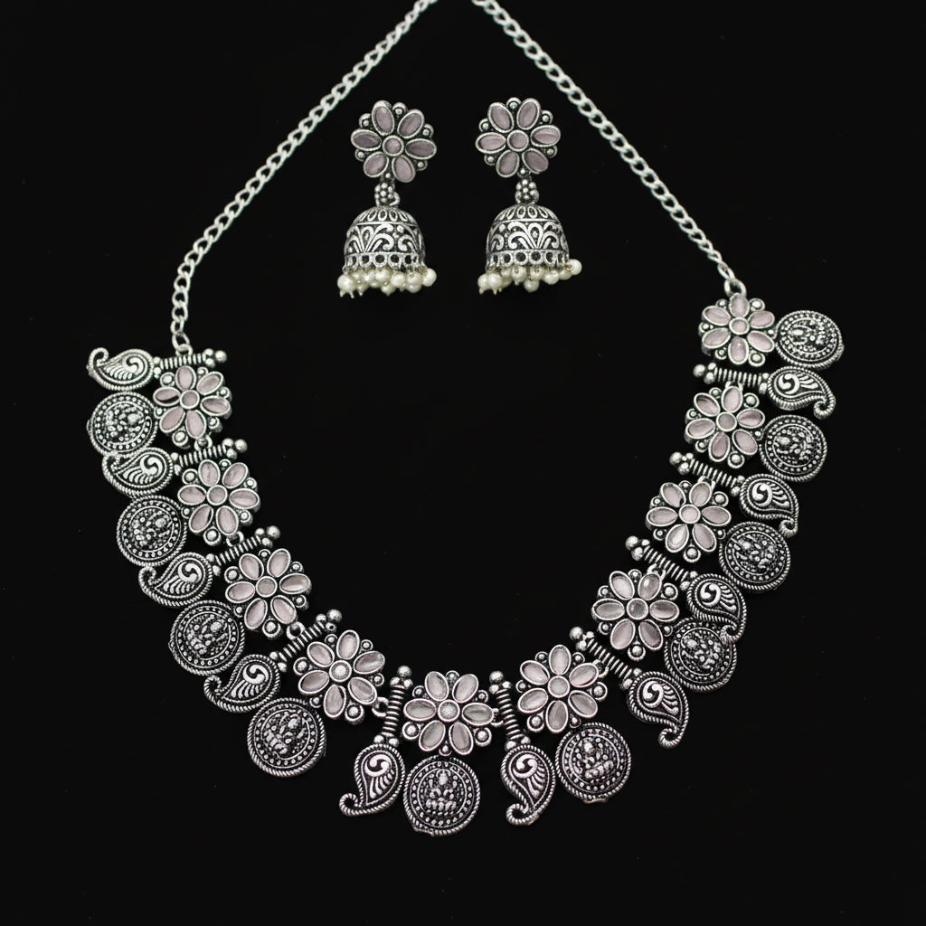 Silver necklace and earrings set on a gray background