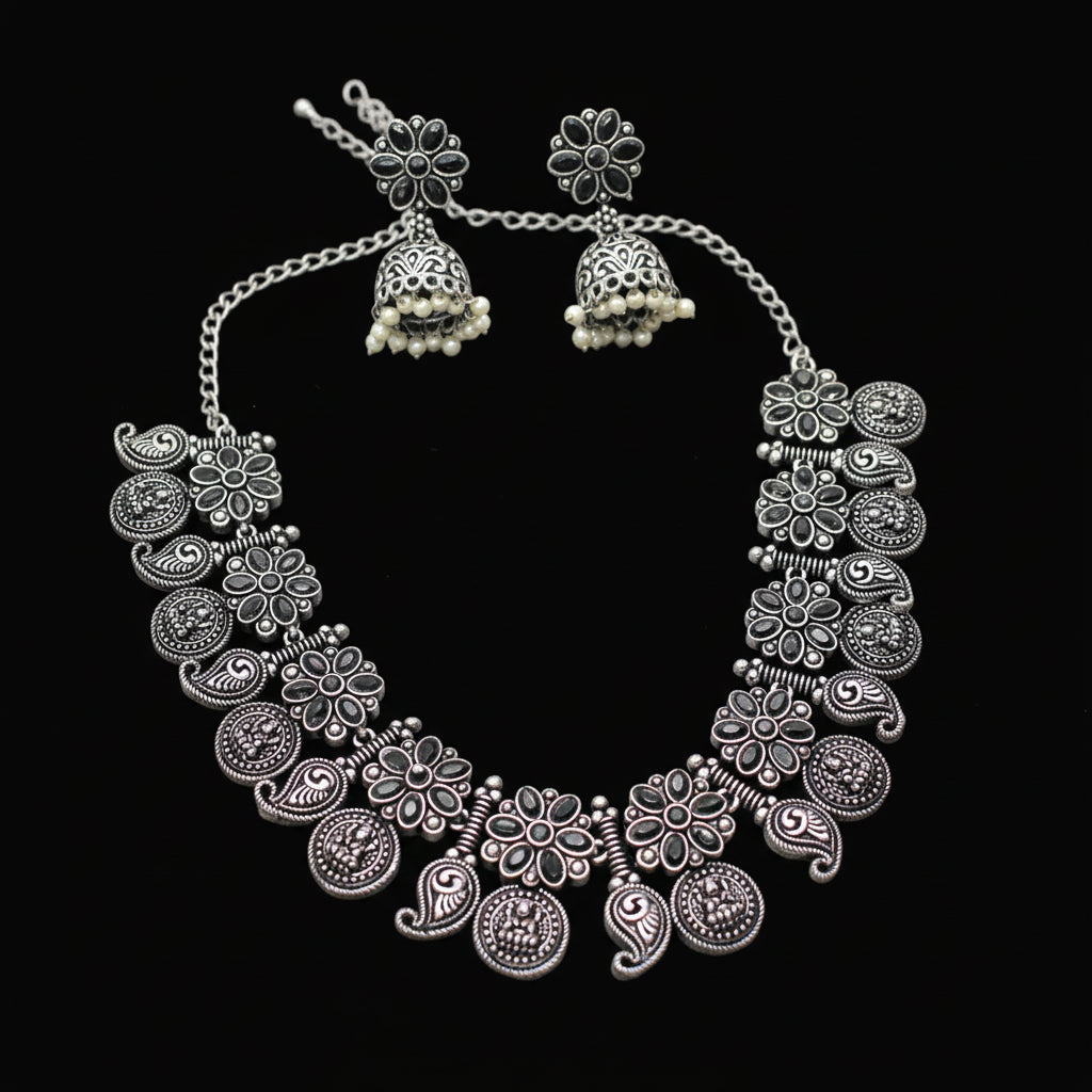Silver necklace and earrings set on a gray background