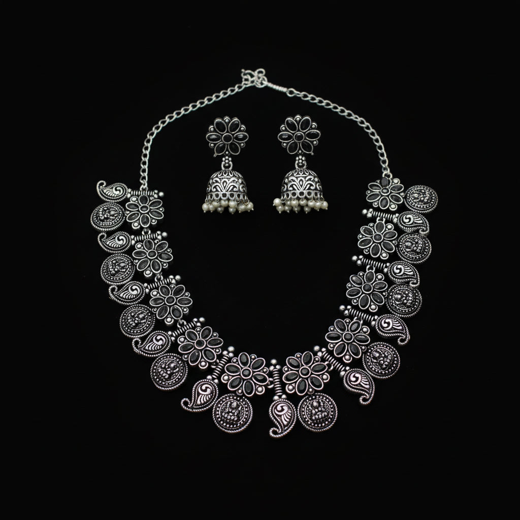 Silver necklace and earrings set on a gray background
