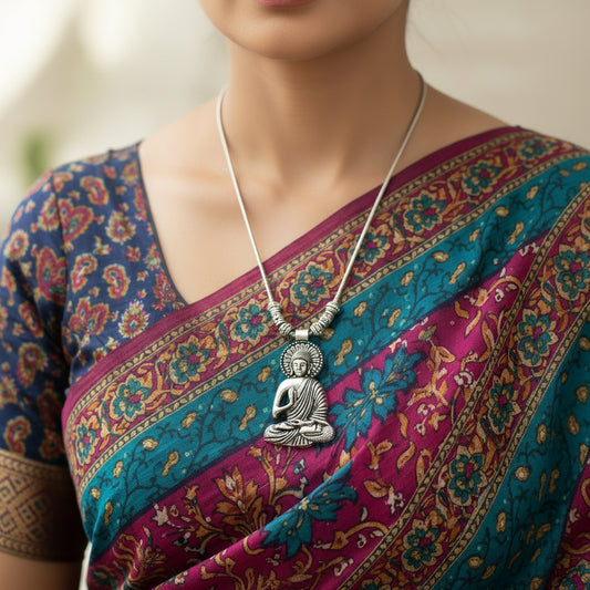 Silver Buddha pendant necklace on a gray background with 'SAHELI' branding.