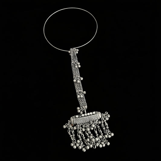 Silver bangle with decorative elements on a gray background, featuring the brand 'Saheli'.