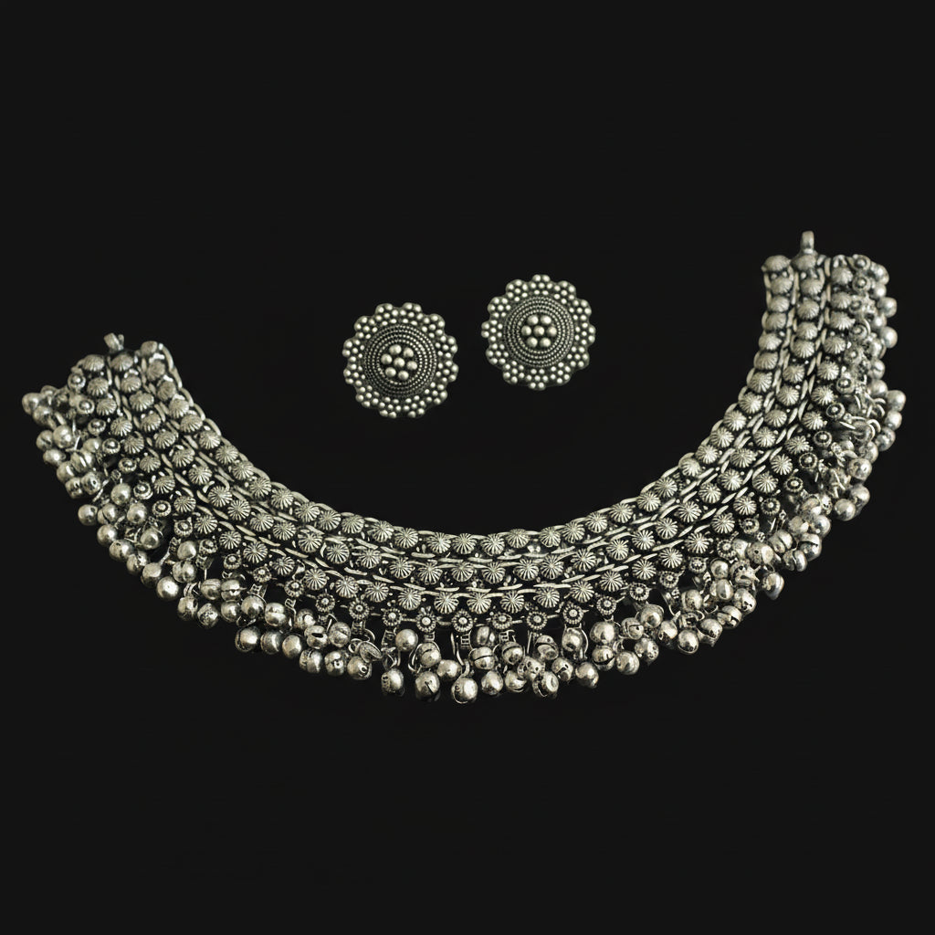 Silver necklace and earrings set on a dark background