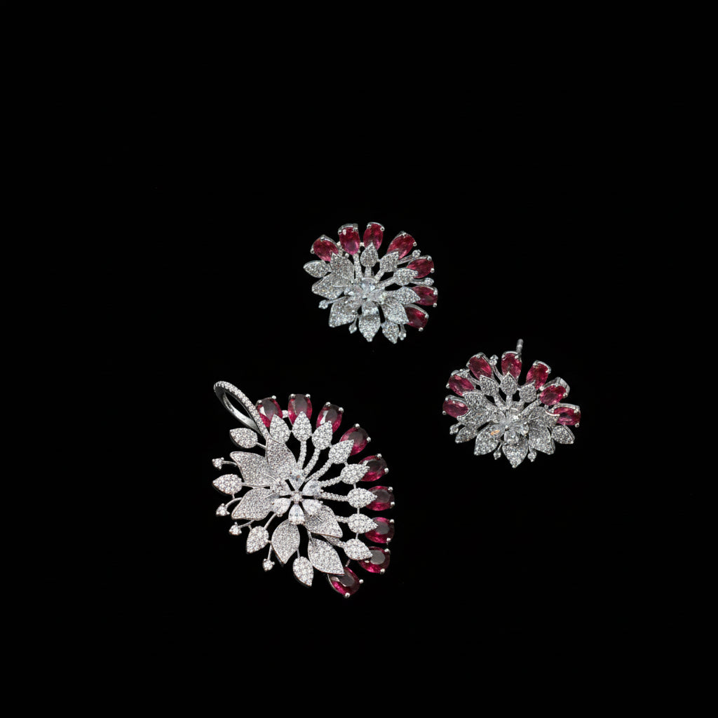 Three decorative brooches with red and silver design on a dark background