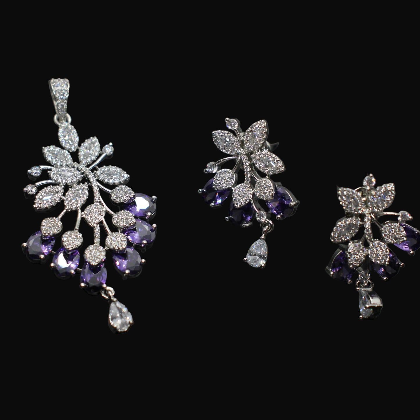 Set of silver and purple gemstone earrings on a dark background
