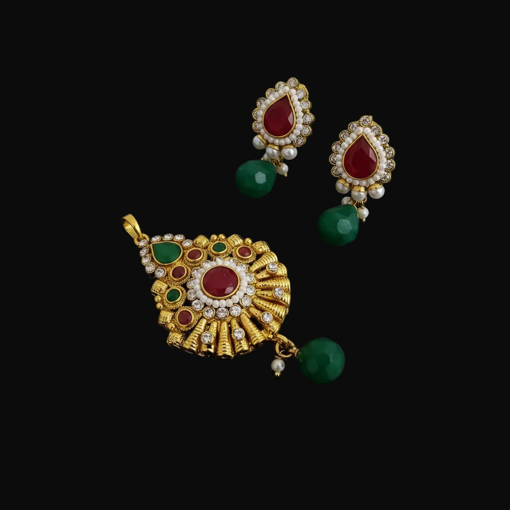 Ornate earrings with red and green stones on a gray background, featuring the brand 'SAHELI'.