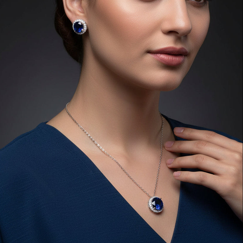 Jewelry set with necklace and earrings featuring blue gemstones on a black background, branded 'SAHELI'.