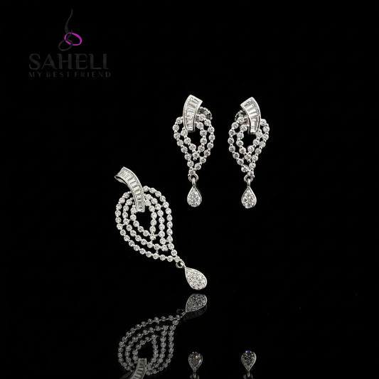 Silver earrings on a black stand with 'Saheli' branding on a dark background