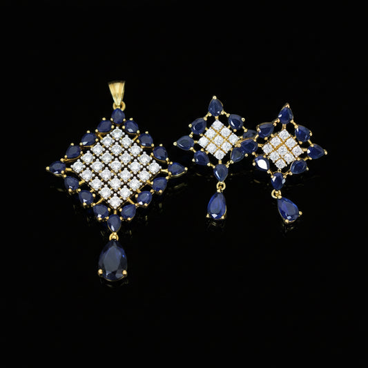 Pair of blue and gold earrings on a gray background with 'Saheli' branding.
