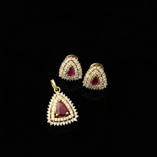Gold earrings with red gemstones on a gray background, featuring the brand 'SAHELI'.