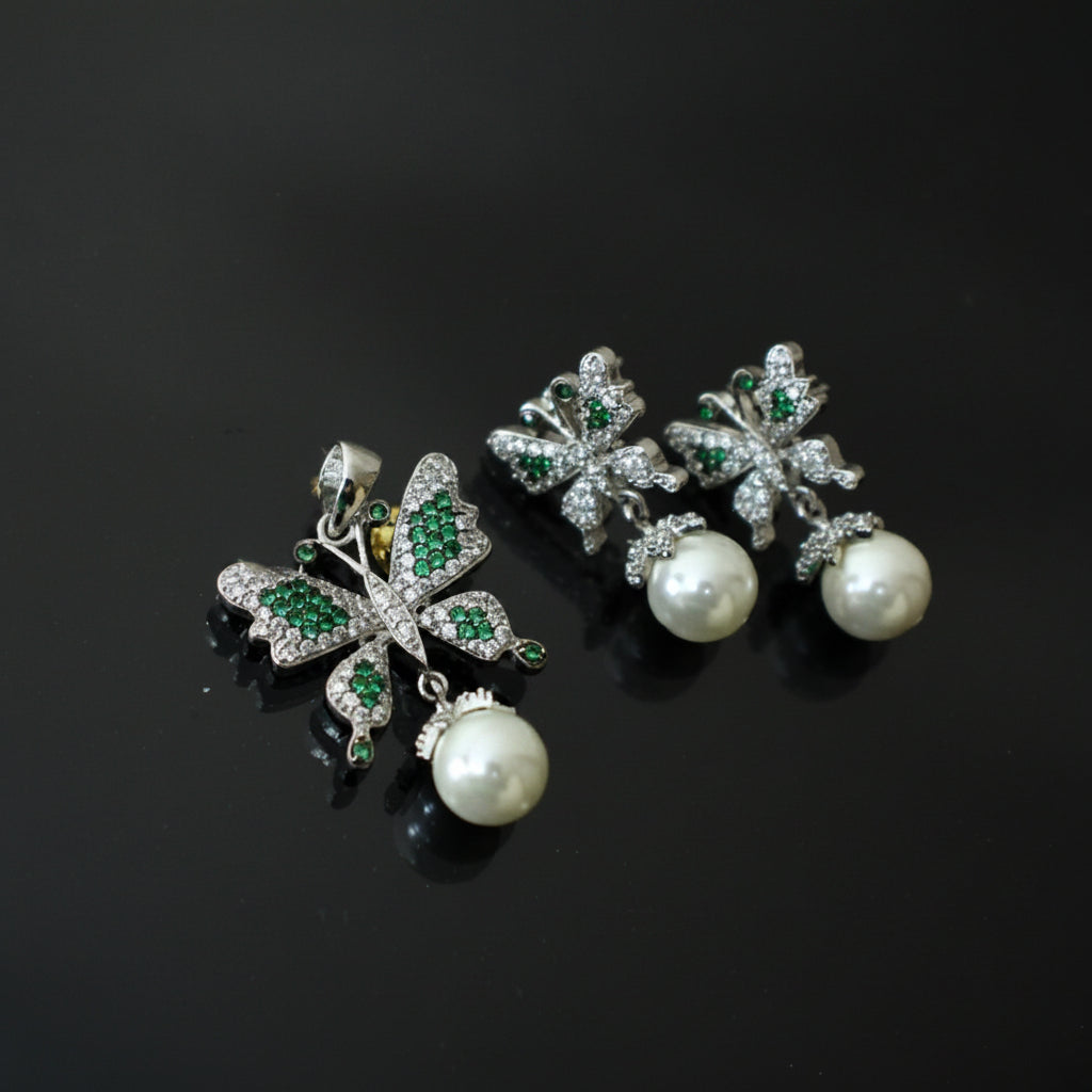 Butterfly-shaped earrings with pearls and gemstones on a dark background, featuring the brand 'Saheli'.