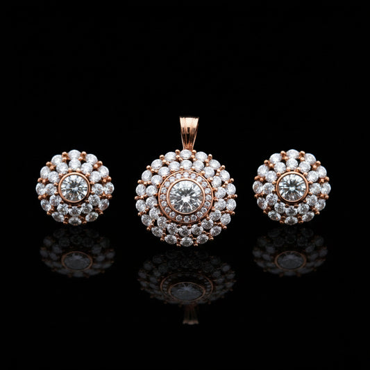 Rose gold jewelry set with pendant and earrings on a gray surface