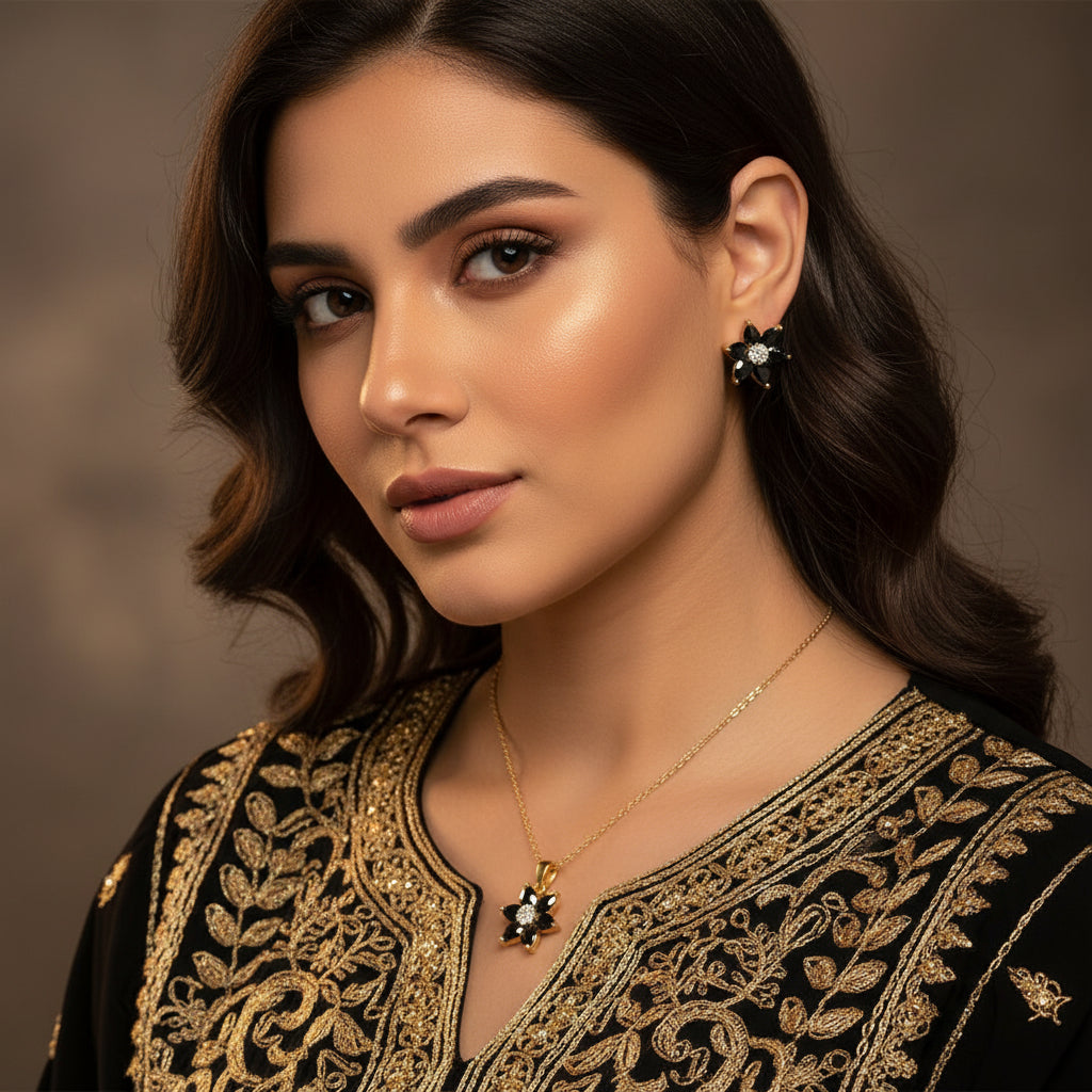 Pair of flower-shaped earrings with black and gold details on a gray background, branded 'SAHELI'.