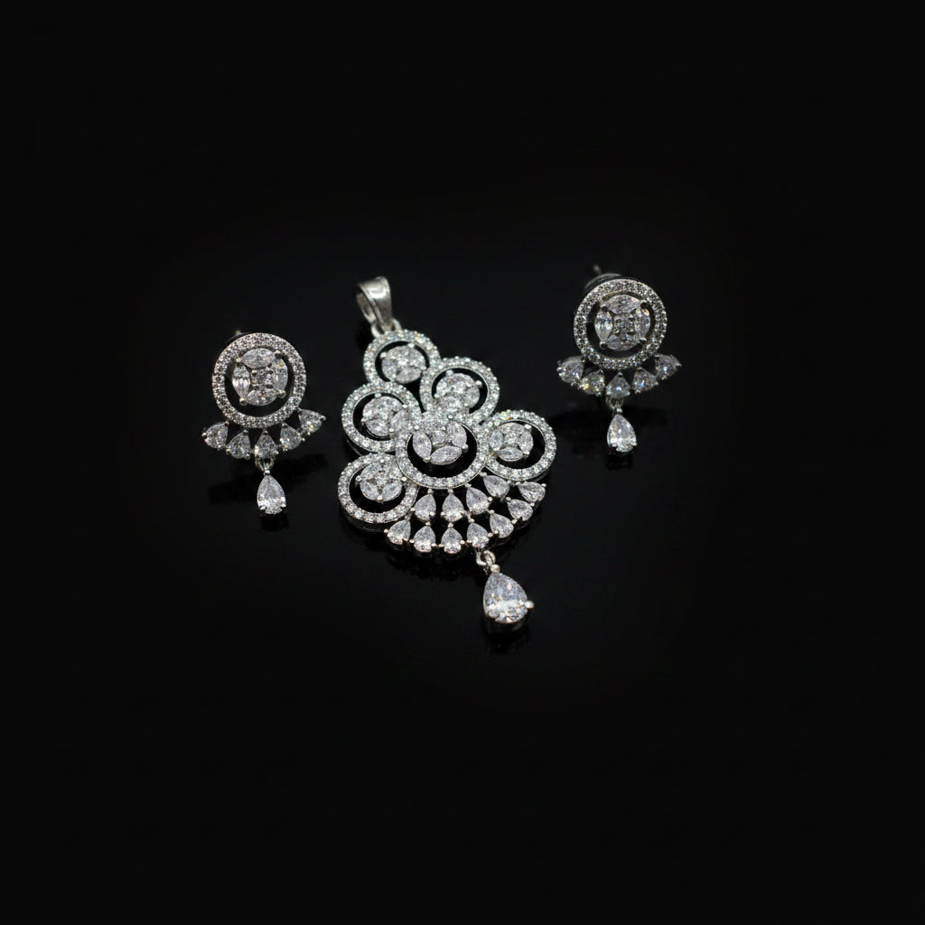 Silver jewelry set with pendant and earrings on a dark gray background