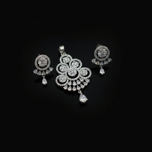 Silver jewelry set with pendant and earrings on a dark gray background
