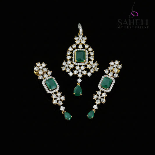 Ornate earrings with green gemstones and gold accents on a dark background, featuring the brand 'Saheli'.