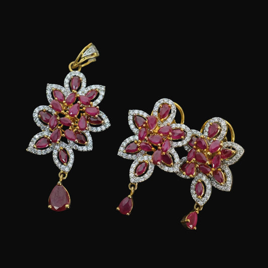 Floral earrings with red stones and gold accents on a dark background, branded 'Saheli'.