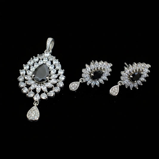 Jewelry set with earrings and a pendant on a dark background, featuring the brand 'Saheli'.