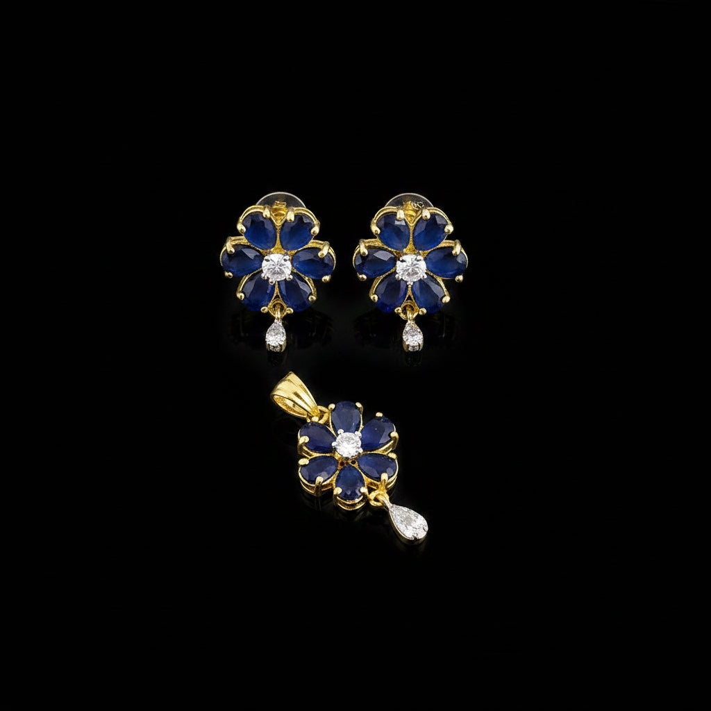 Floral earrings and pendant with blue gemstones on a gray background, branded 'Saheli'.