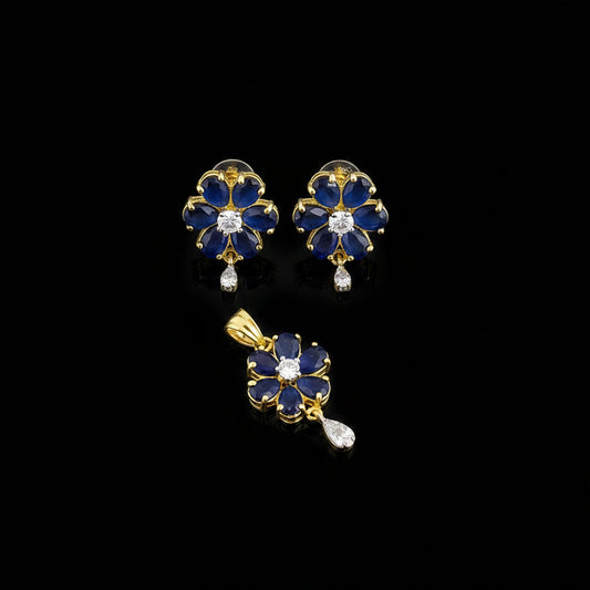 Floral earrings and pendant with blue gemstones on a gray background, branded 'Saheli'.