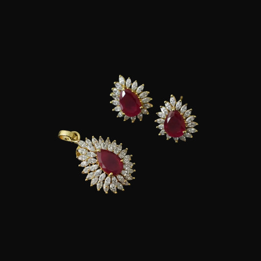 Gold and red gemstone earrings with 'SAHELLI' branding on a dark background
