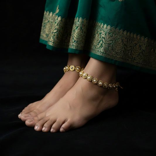 Gold necklace with gemstones on a dark background, featuring the brand 'Saheli'.