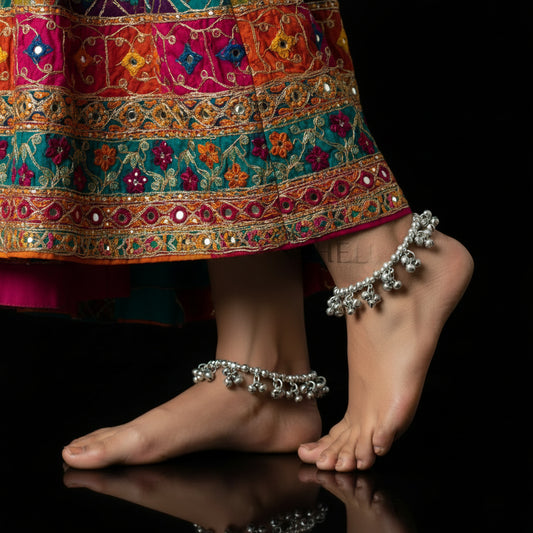 Silver jewelry set with necklace and bracelet on a dark background, featuring the brand 'Saheili'.