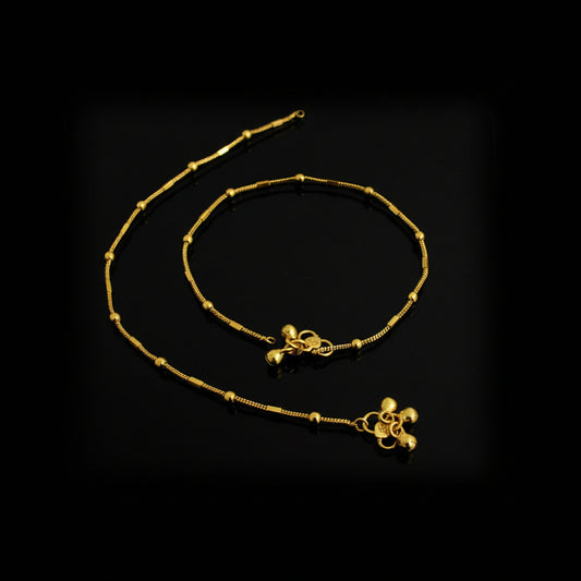 Gold anklets on a black background