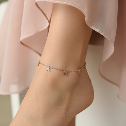 Rose gold necklace with animal pendants on a white stand against a dark background