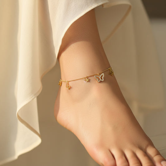 Gold necklace with butterfly pendants on a branded display card against a dark background