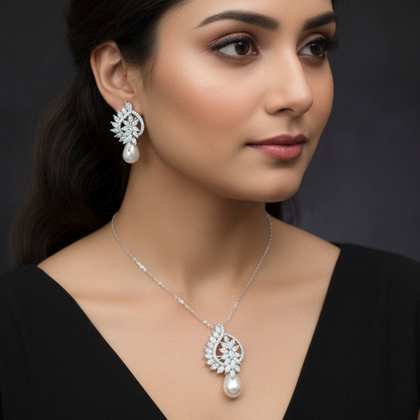 Jewelry set with silver earrings and a necklace on a dark background