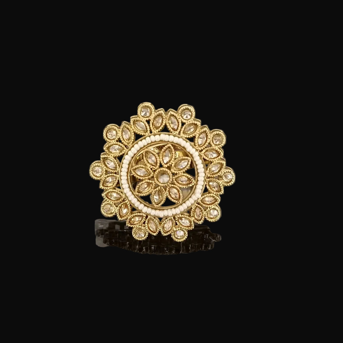 Gold ring with intricate design on a gray background