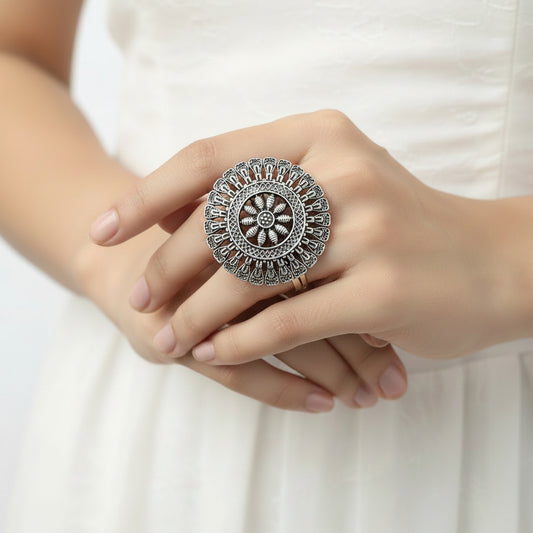 Silver ring with intricate design on a gray background, featuring the brand 'Saheli'.