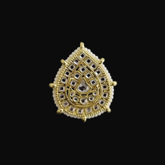 Gold and silver teardrop-shaped jewelry piece on a dark background