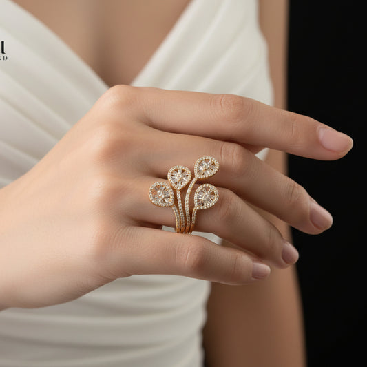 Gold floral ring on a black glove with 'Saheli' branding.
