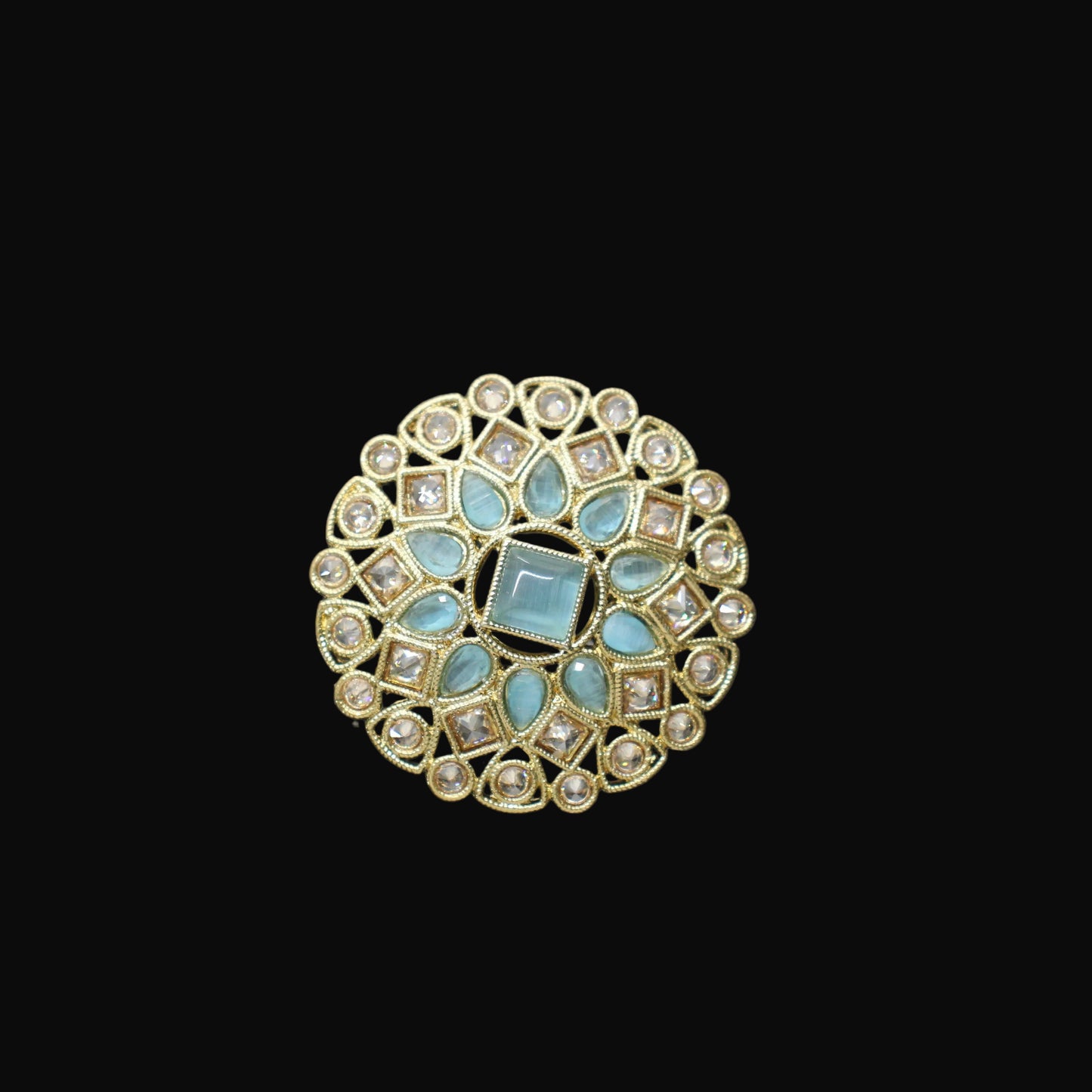 Decorative ring with turquoise stones on a black mannequin hand against a gray background