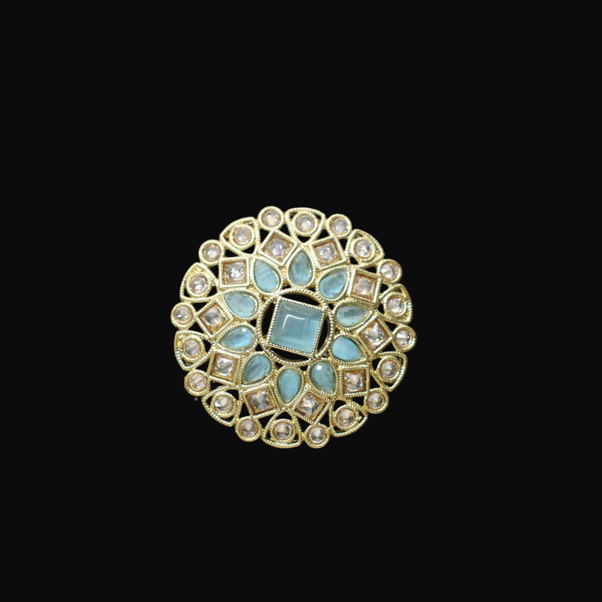 Decorative ring with turquoise stones on a black mannequin hand against a gray background