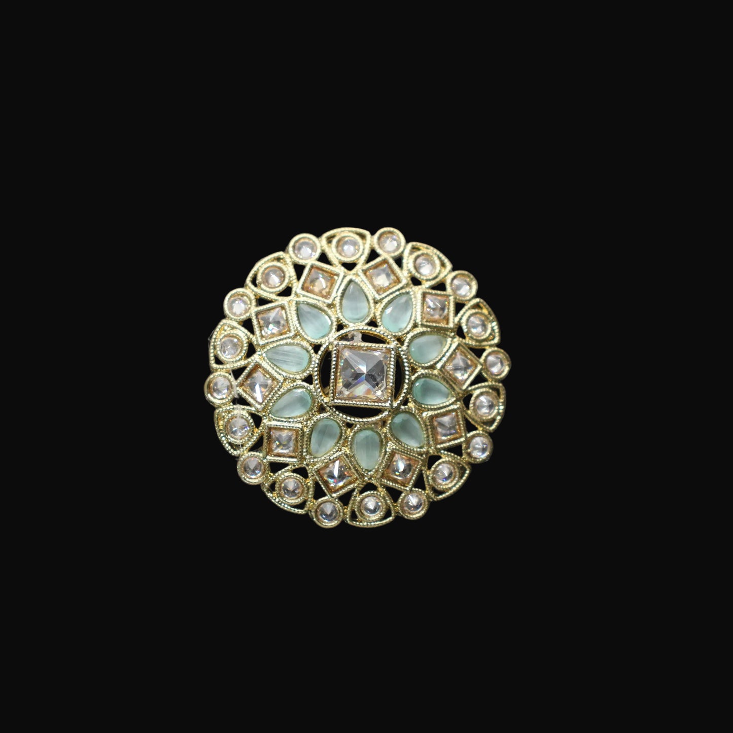 Decorative ring with gemstones on a black mannequin hand against a dark background