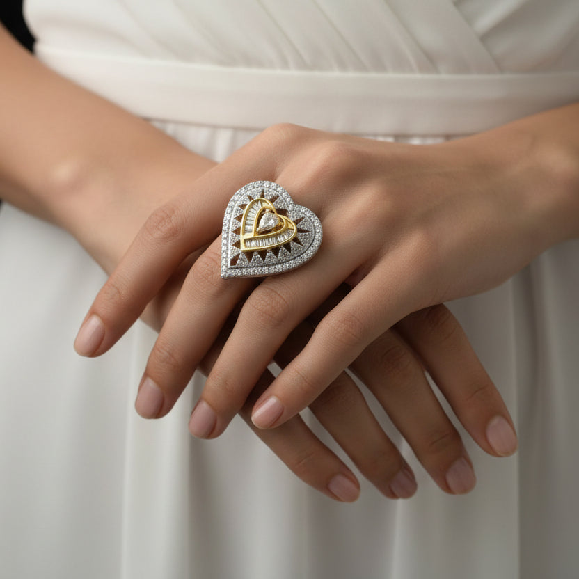 Gold and silver ring on a black hand with 'SAHELI' branding.